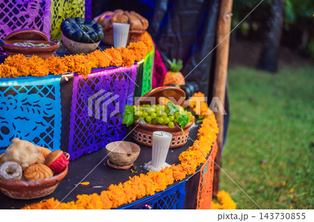 Fruit and candle offerings displayed with colorful paper cut decorations. 143730855