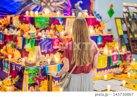 Woman discovering a festive altar filled with traditional offerings. Woman discovering a festive altar filled with traditional offerings. 143730867
