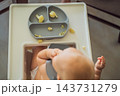 Infant trying cauliflower florets during a complementary feeding meal. 143731279