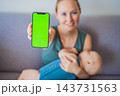 Smartphone green screen presented by a mother nursing her infant at home. 143731563