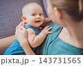 Mother sharing a happy interaction with her infant son at home. 143731565