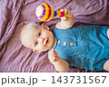Baby learning through touch and mouth exploration of a rattle. 143731567