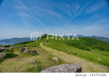 青空と緑豊かな大草原が広がる長崎県平戸市の川内峠 遠くに海と山並みを望む雄大な絶景 143733286