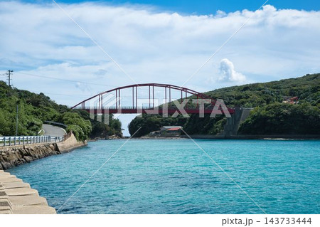 青空とエメラルドグリーンの海に映える長崎県対馬市の赤いアーチ橋・赤島大橋の絶景 143733444
