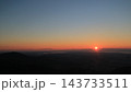 地平線近くの雲から昇る朝日と、オレンジから青へ移る朝焼けの空 143733511