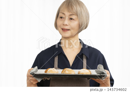 手作りパンを楽しむシニア女性 手作りパンを楽しむシニア女性 143734602