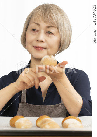手作りパンを楽しむシニア女性 手作りパンを楽しむシニア女性 143734623