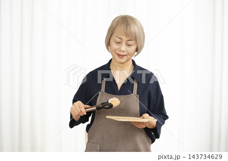 手作りパンを楽しむシニア女性 手作りパンを楽しむシニア女性 143734629