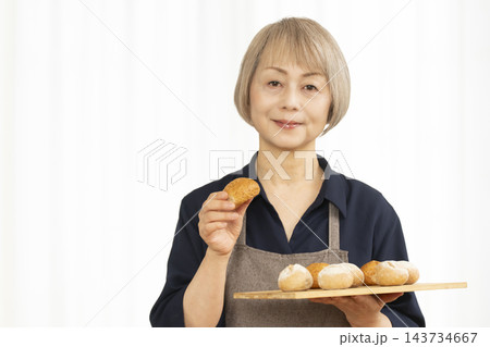 手作りパンを楽しむシニア女性 手作りパンを楽しむシニア女性 143734667