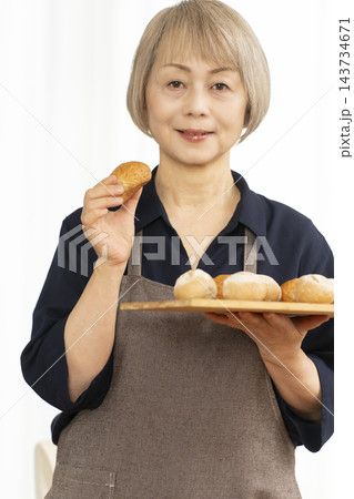 手作りパンを楽しむシニア女性 143734671