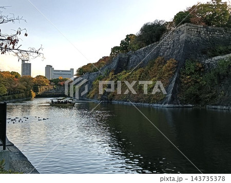 大阪城公園の堀と石垣、遊覧船が浮かぶ秋の風景 143735378