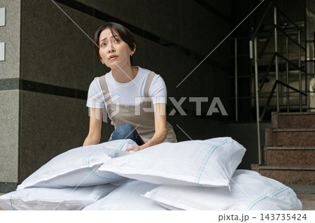 土嚢を設置する女性 土嚢を設置する女性 143735424