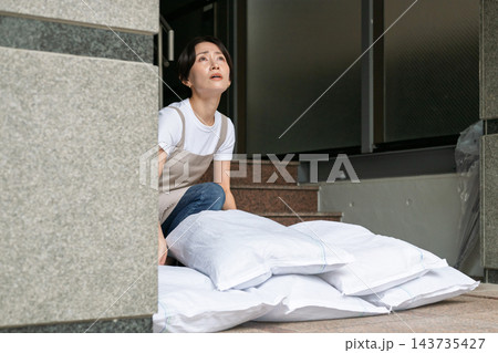 土嚢を設置する女性 143735427