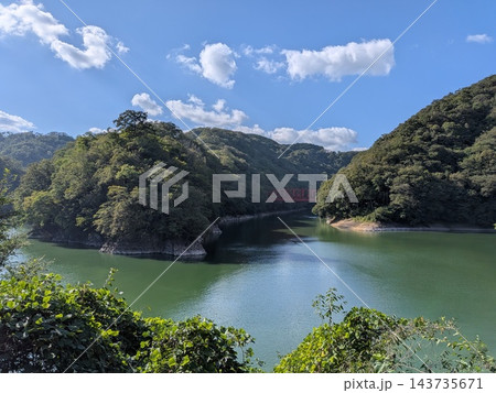 青空と緑豊かな山々に包まれた帝釈峡・神龍湖と奥に見える赤い橋 青空と緑豊かな山々に包まれた帝釈峡・神龍湖と奥に見える赤い橋 143735671