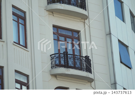 Apartment building facade with balconies and windows in daylight Apartment building facade with balconies and windows in daylight 143737613