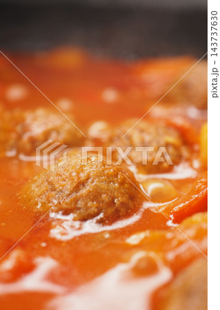 Meatballs simmer in tomato sauce during cooking on a stove Meatballs simmer in tomato sauce during cooking on a stove 143737630