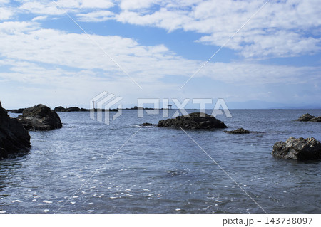 青空の森戸海岸の風景　ごつい岩たちの先に裕次郎灯台と鳥居がみえます 143738097