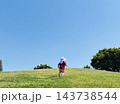 公園の丘を駆け上がる子供　後ろ姿　晴天の芝生の上 143738544