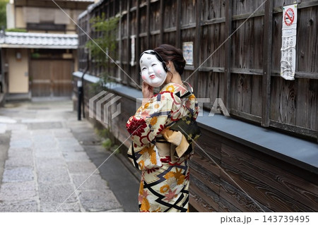 お面で顔を隠している着物の女性 お面で顔を隠している着物の女性 143739495