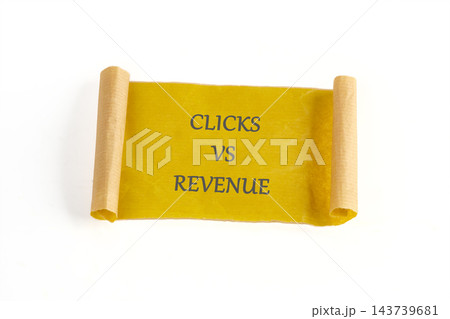 Yellow paper banner with the words Clicks vs Revenue, isolated on a white background in a studio setting 143739681