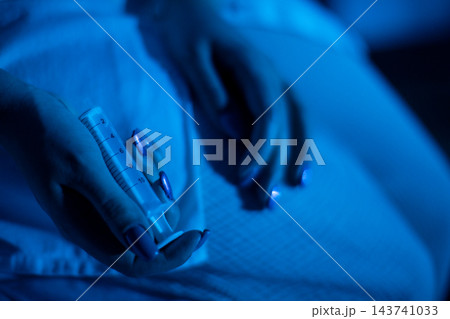 Intimate medication moment. Soft focus captures delicate pill administration scene. Serene image showcasing person handling medication with gentle care in ambient lighting 143741033