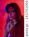 Creative night scene. Musician in evening atmosphere. Portrait of artist with soft hoodie glow. Nighttime artistic depiction featuring musician in ambient lighting Creative night scene. Musician in evening atmosphere. Portrait of artist with soft hoodie glow. Nighttime artistic depiction featuring musician in ambient lighting 143741064