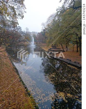 Beautiful autumn landscape of a city canal surrounded by colorful trees 143743214