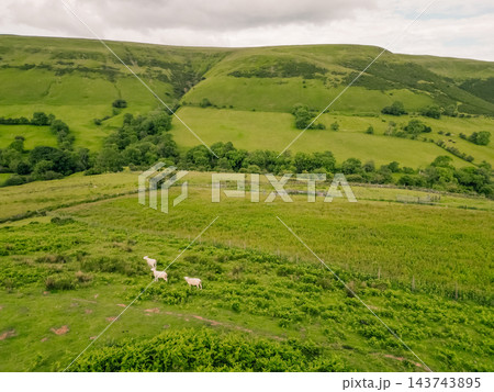 Aerial view of a scenic mountain valley with a winding road through the rugged landscape of Brecon Beacons National Park in Wales, United Kingdom Powys, Wales - 28 August 2026. Aerial view of a scenic mountain valley with a winding road through the rugged landscape of Brecon Beacons National Park in Wales, United Kingdom Powys, Wales - 28 August 2026. 143743895