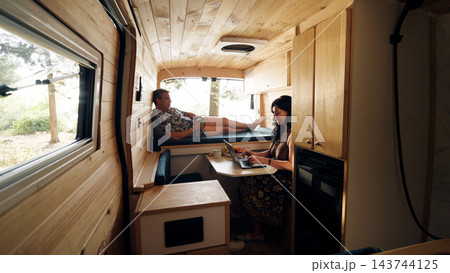 Mature couple enjoying van life and remote work 143744125
