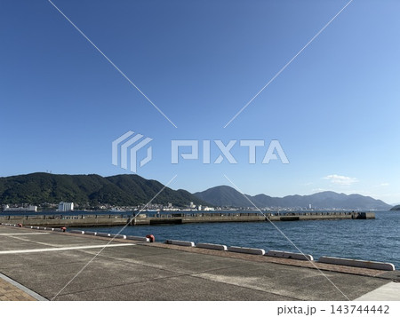 青空と海に囲まれた港の風景と山並み 青空と海に囲まれた港の風景と山並み 143744442