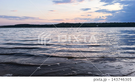 Gentle waves on a lake at dusk beneath a pastel sky 143746305