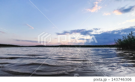 Gentle waves on a lake beneath a pastel evening sky 143746306