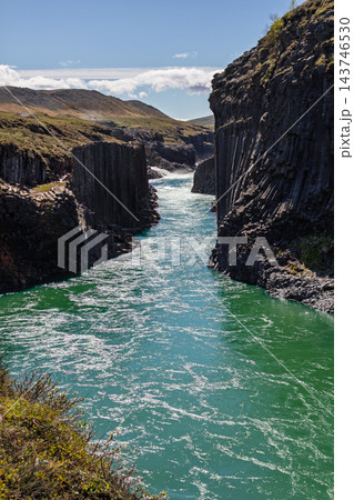Turquoise Jokla river between columnar basalt cliffs in Studlagil canyon, Iceland Turquoise Jokla river between columnar basalt cliffs in Studlagil canyon, Iceland 143746530
