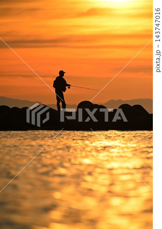 夕日に照らされた海岸と人物のシルエット(新潟県新潟市) 夕日に照らされた海岸と人物のシルエット(新潟県新潟市) 143747016