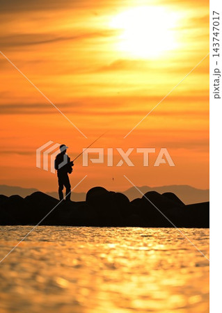 夕日に照らされた海岸と人物のシルエット(新潟県新潟市) 夕日に照らされた海岸と人物のシルエット(新潟県新潟市) 143747017