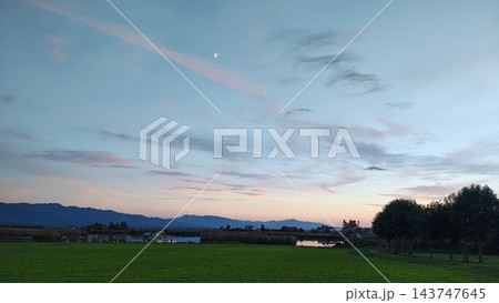 夕焼けに染まる空と木々に囲まれた公園の風景 夕焼けに染まる空と木々に囲まれた公園の風景 143747645