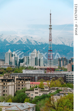 Almaty city skyline with snow capped mountains, red and white TV tower and green spring trees Almaty city skyline with snow capped mountains, red and white TV tower and green spring trees 143748421