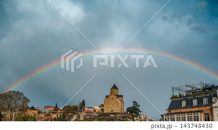 Rainbow arching over Metekhi Church and colorful old town houses on a cliff in Tbilisi, Georgia 143748430