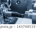 Outside thread making process on steel pipe parts using a CNC lathe machine in a blue tone scene 143748519