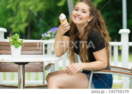 Young woman eating ice cream Young woman eating ice cream 143750179