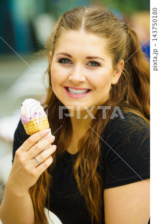 Young woman eating ice cream 143750180