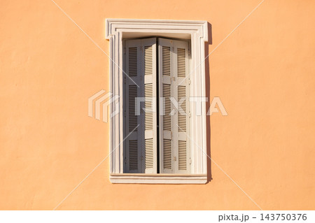 Old window shutters on orange home Old window shutters on orange home 143750376