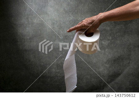 Man's right hand holding a roll of white toilet paper Man's right hand holding a roll of white toilet paper 143750612