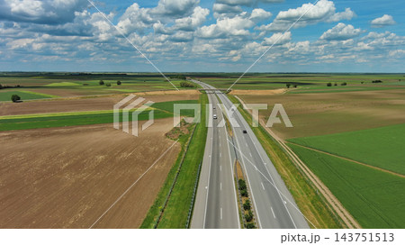 Aerial view of highway crossing green agricultural fields 143751513