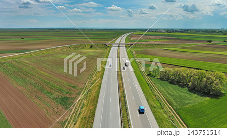 Aerial view of highway crossing green agricultural fields 143751514