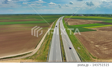 Aerial view of highway crossing green agricultural fields 143751515