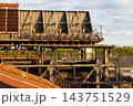 Horizontal close up of historic industrial heat exchanger cooling plant with steel frame corrugated roof metal panels and catwalk railings in Duisburg Ruhr region North Rhine Westphalia Germany 143751529