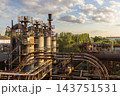 High angle telephoto landscape of historic industrial gas cleaning plant with gas scrubber towers flare stack curved steel pipelines and cloudy sky in Duisburg Ruhr region Westphalia Germany 143751531