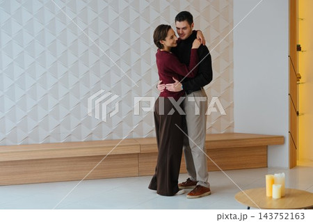Couple sharing an embrace in a modern indoor space during the day Couple sharing an embrace in a modern indoor space during the day 143752163