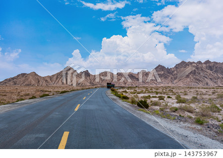 Scenic Highway Through Arid Tibetan Plateau Mountains Under Blue Sky 143753967